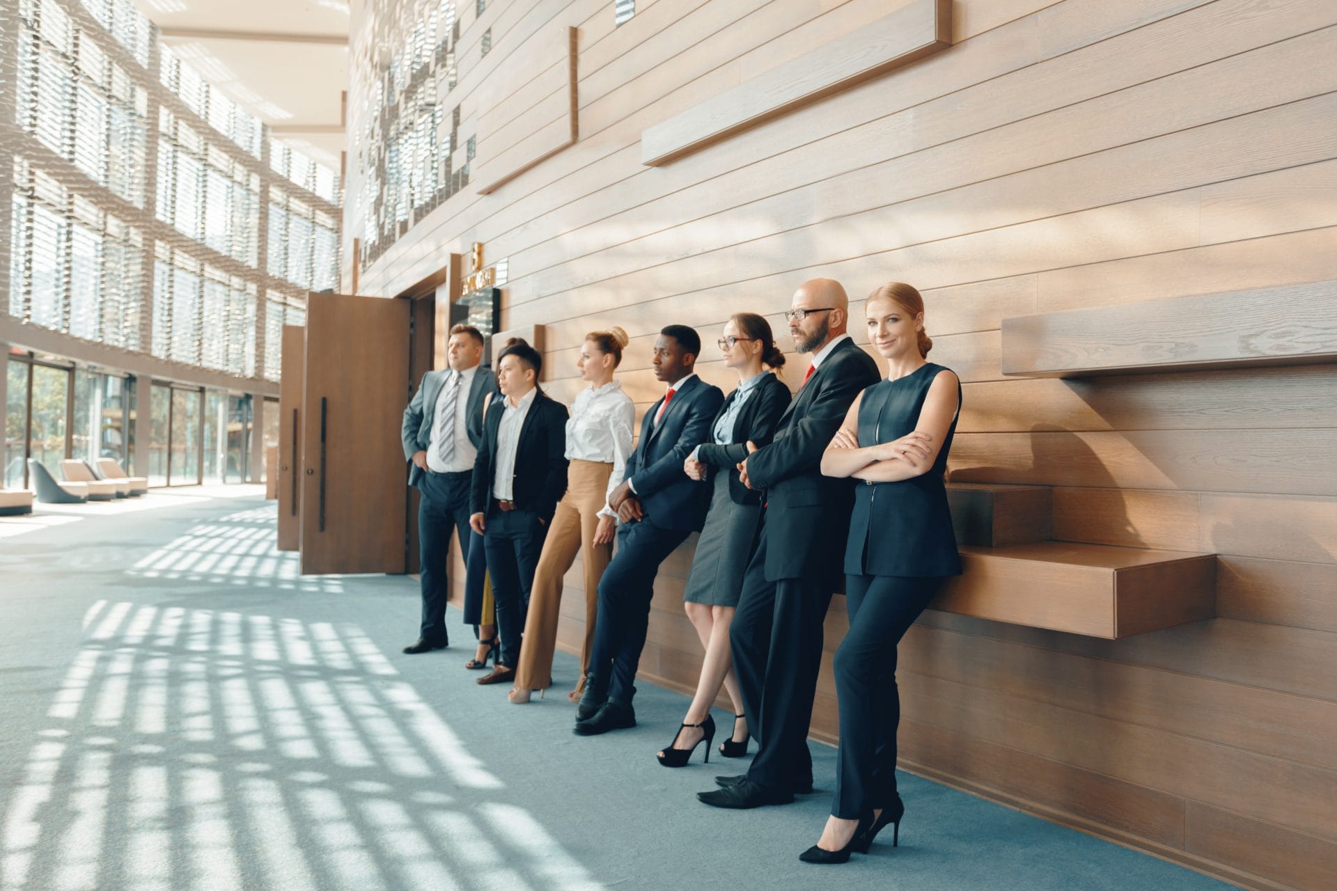 Diverse team of professionals standing confidently in a bright modern office, reflecting unity, purpose, and innovation.