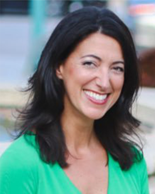 Professional headshot of a woman with dark hair wearing a bright green top, smiling in an outdoor setting.