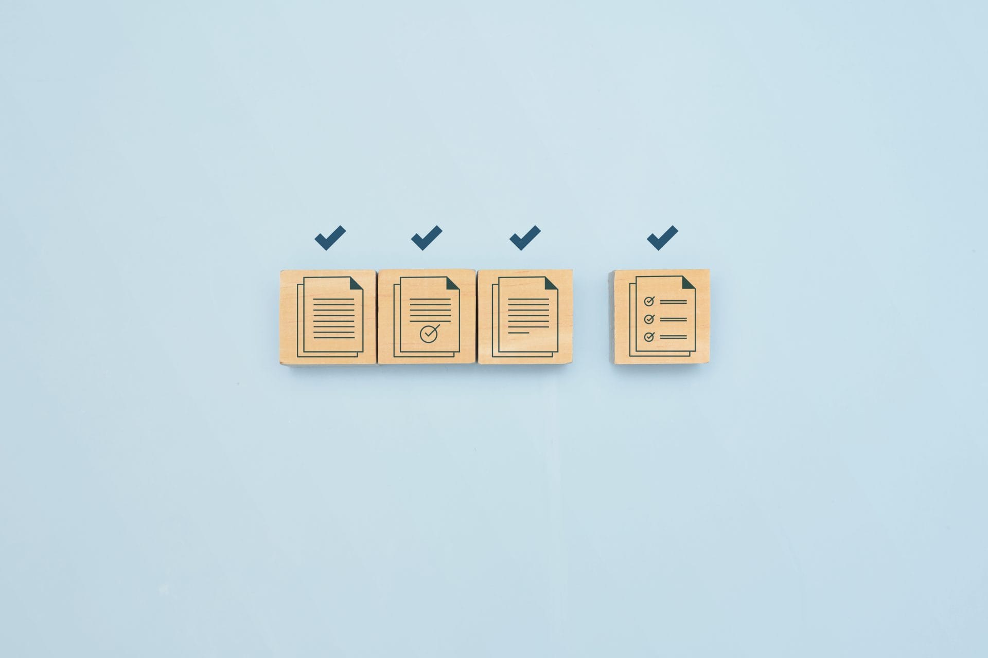 Wooden blocks with checkmarks and document icons on a blue background, symbolizing compliance and completed tasks.