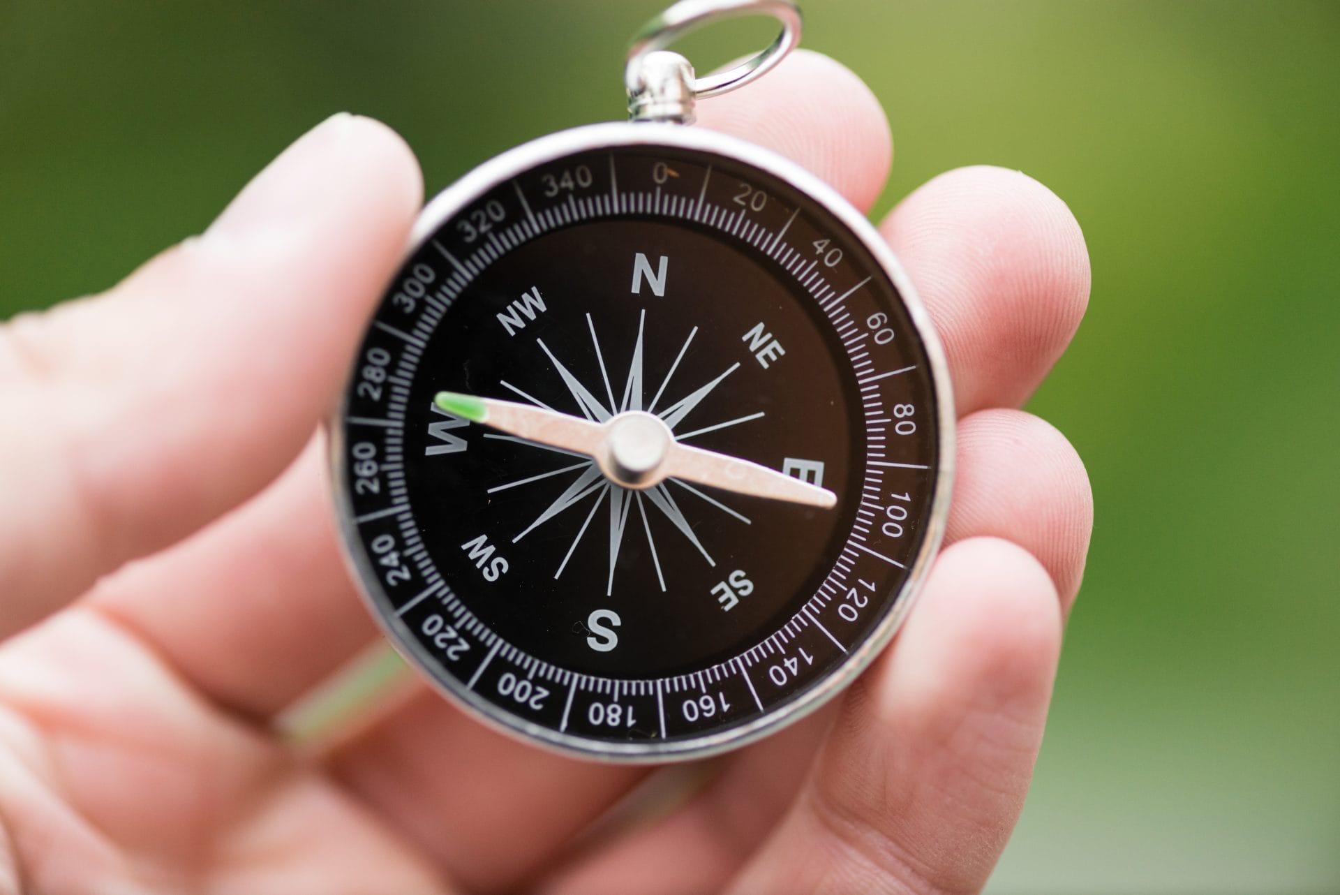 Close-up of a person holding a compass, symbolizing guidance and direction on a career path.