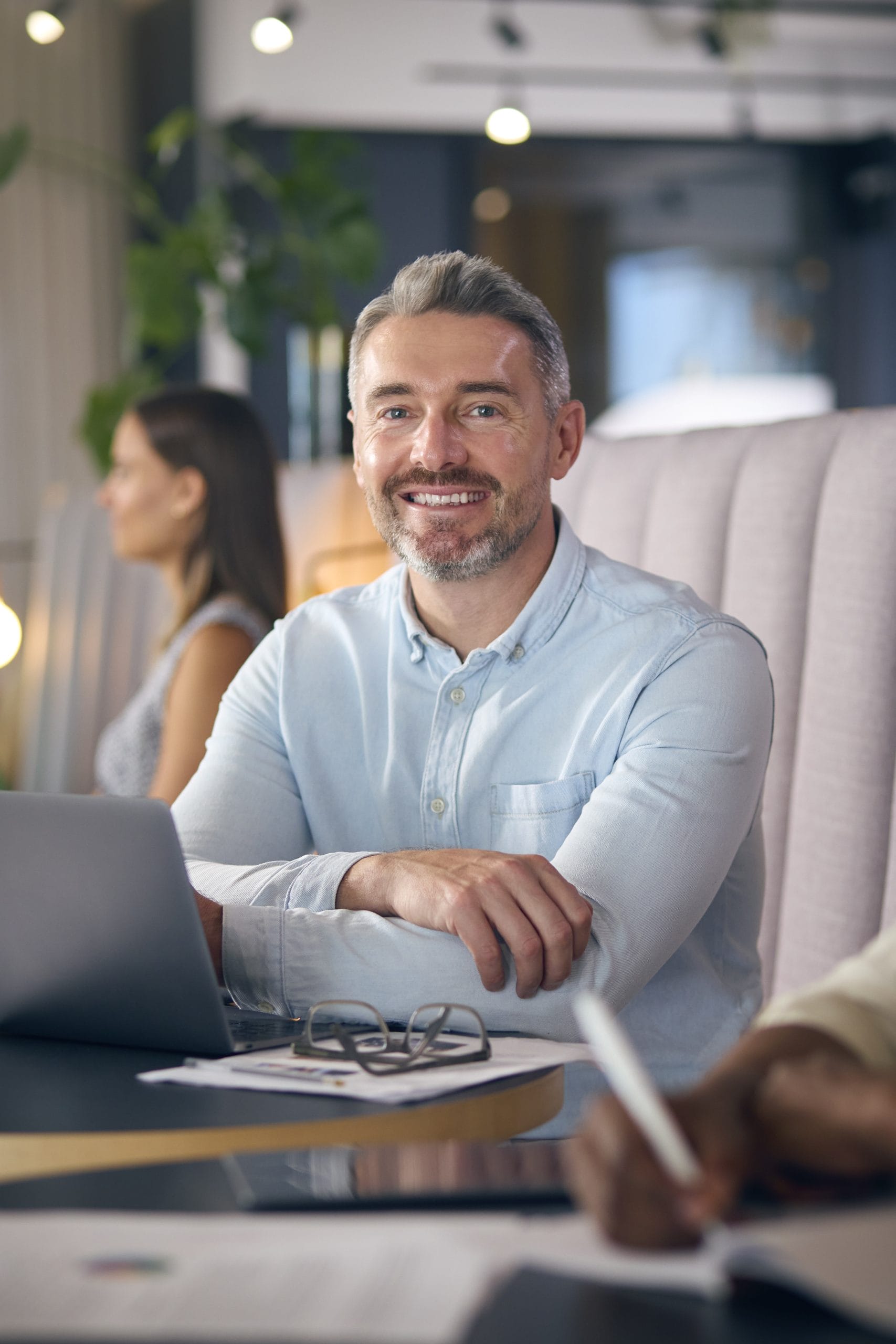 Smiling man seated in a professional setting, representing accessible employment opportunities and inclusive career services.