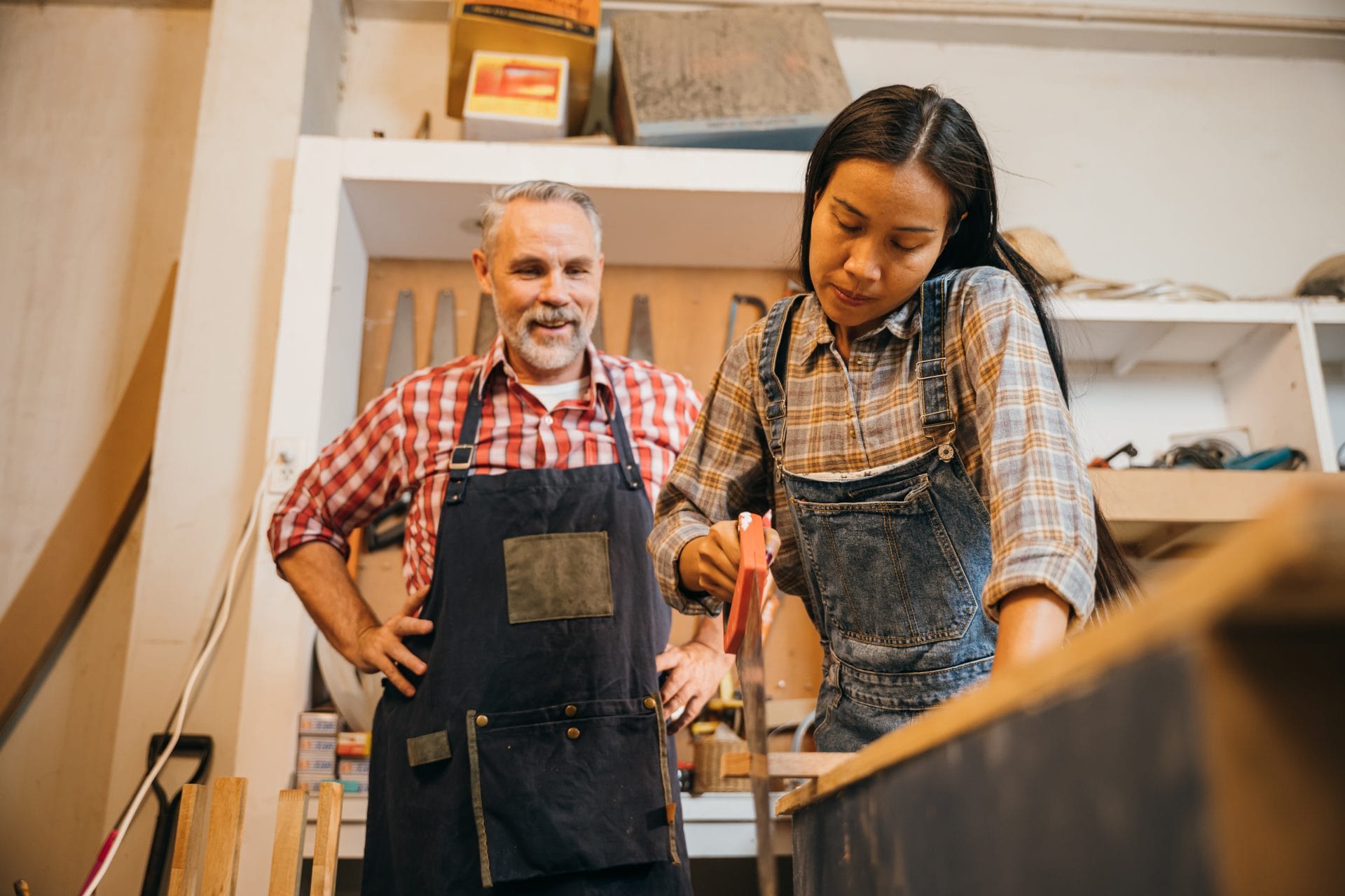 Apprentice learning from an experienced mentor in a workshop, representing structured training and workforce growth.