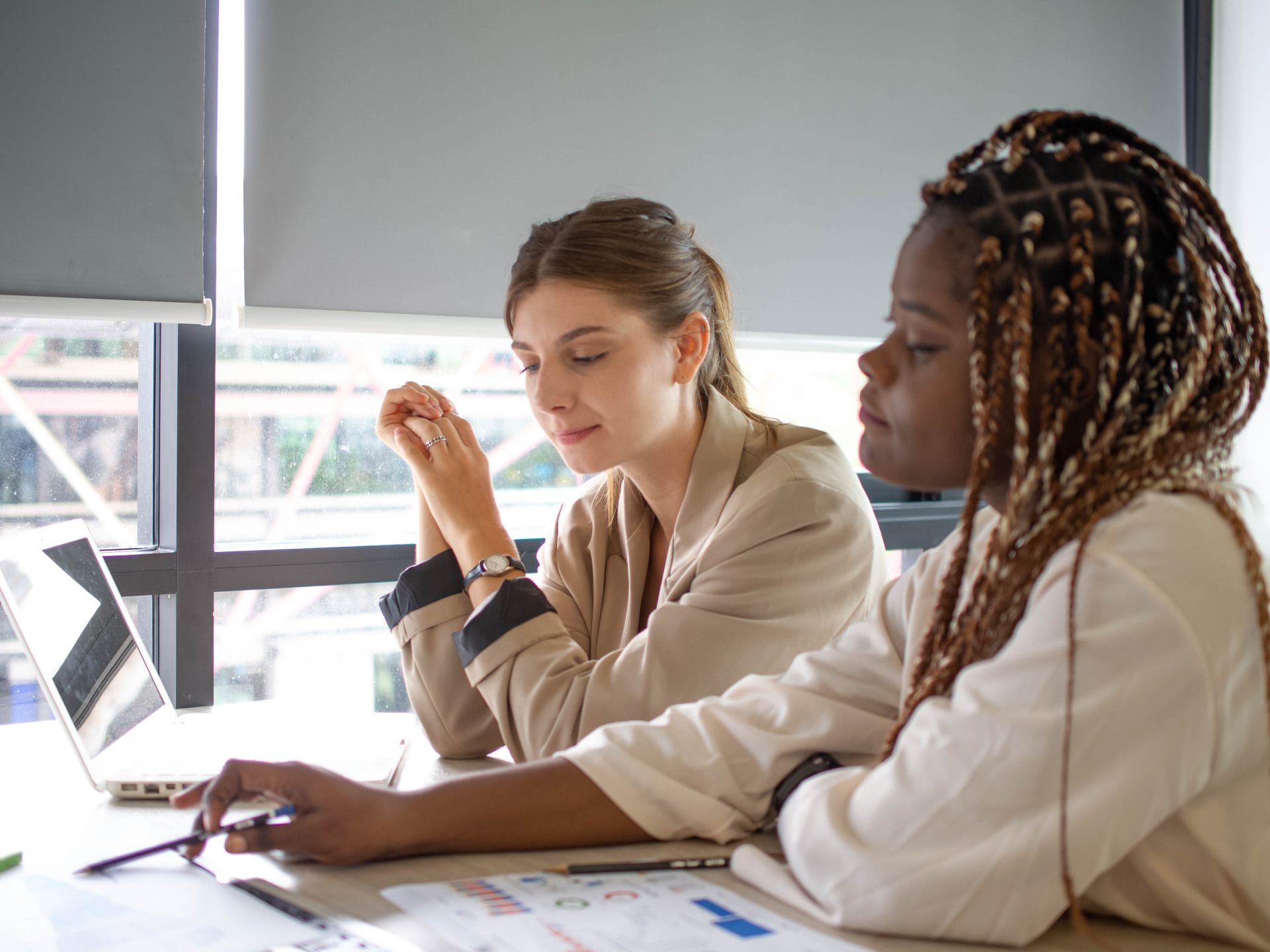 Two professionals meeting at a desk, reviewing documents and discussing training plans.