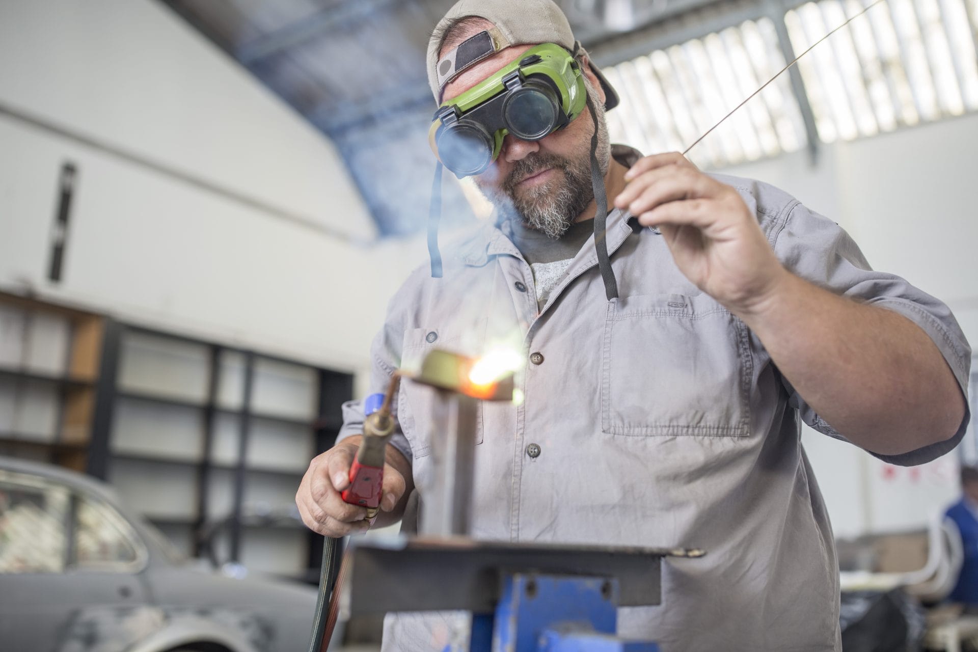 Skilled worker wearing protective goggles while welding, representing career training and certification opportunities.
