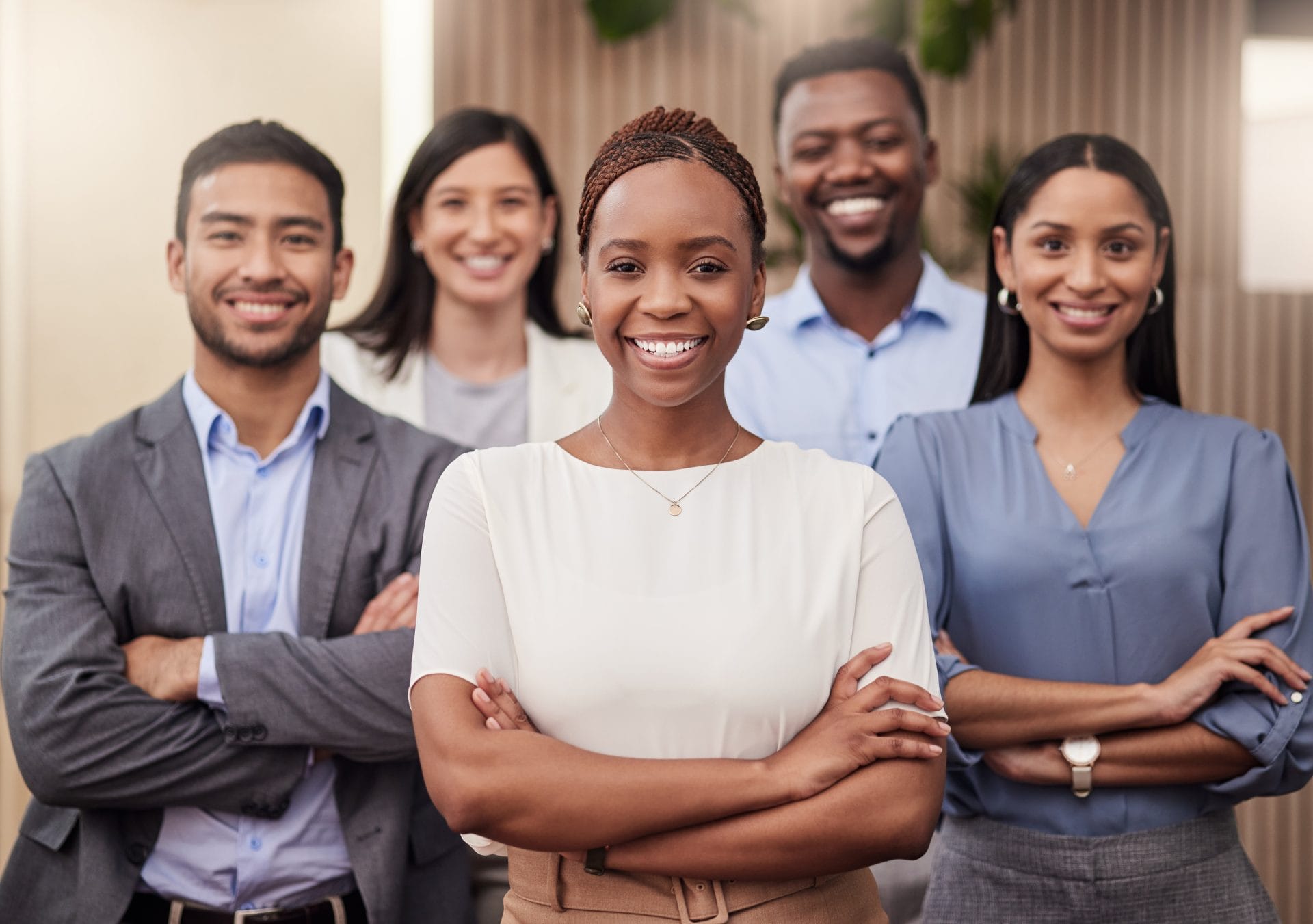 Smiling professional woman standing with a diverse group of colleagues, representing business partnership and workforce success.