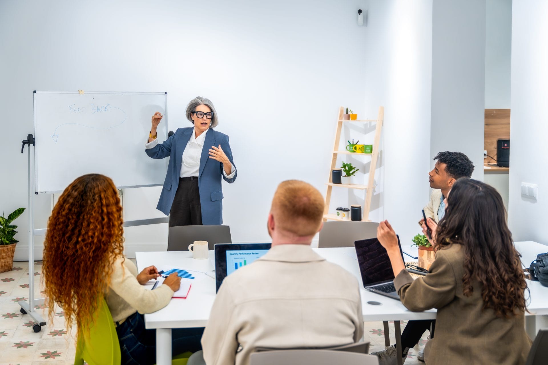 Professional instructor leading a training session with employees in a classroom setting.