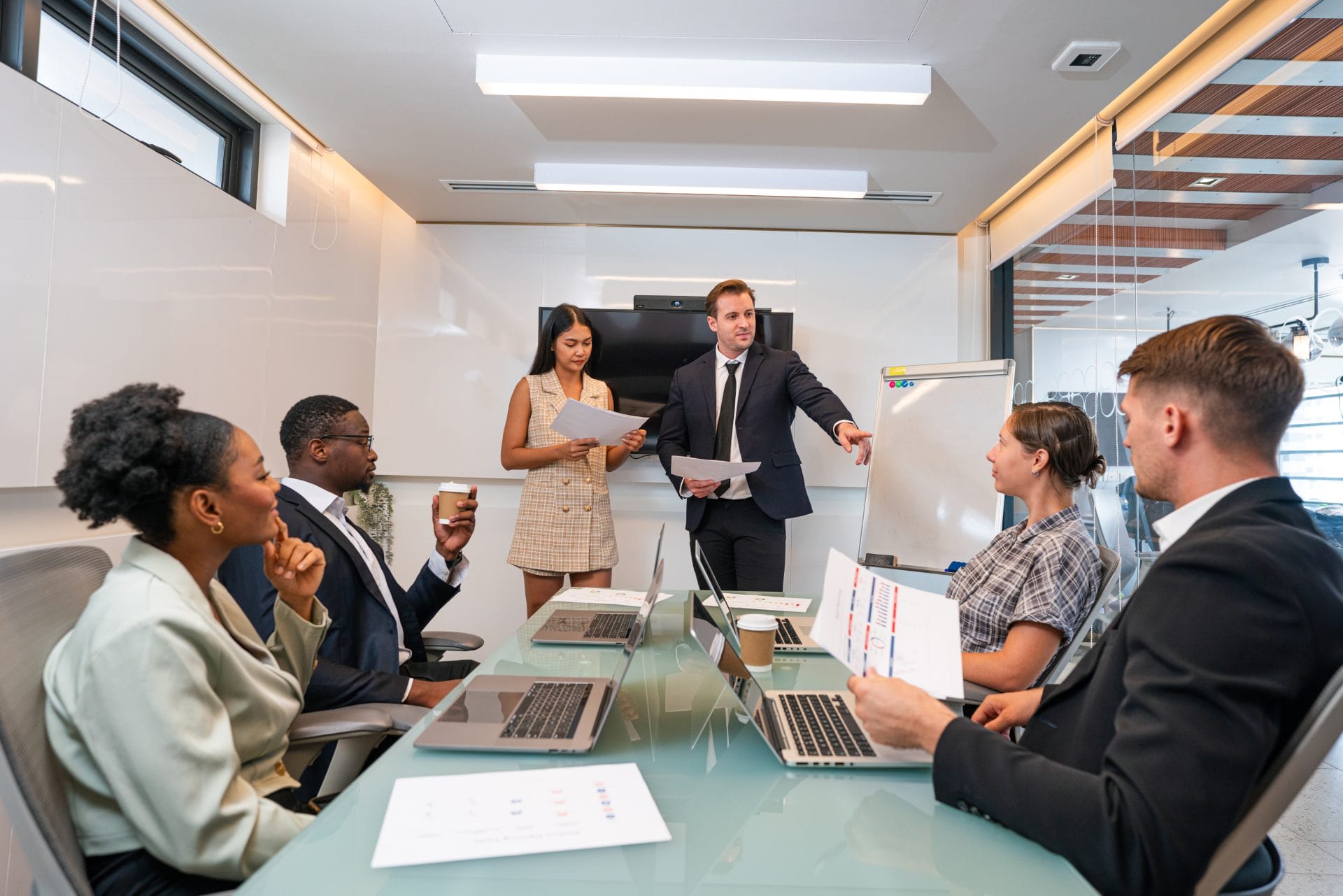 Business meeting with professionals gathered around a conference table as a presenter leads a discussion.
