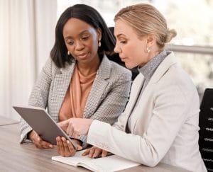 Two business professionals reviewing information on a tablet, representing expert guidance through organizational change.