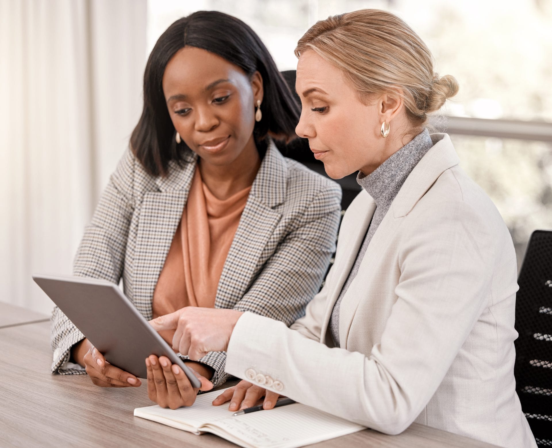 Two business professionals reviewing information on a tablet, representing expert guidance through organizational change.