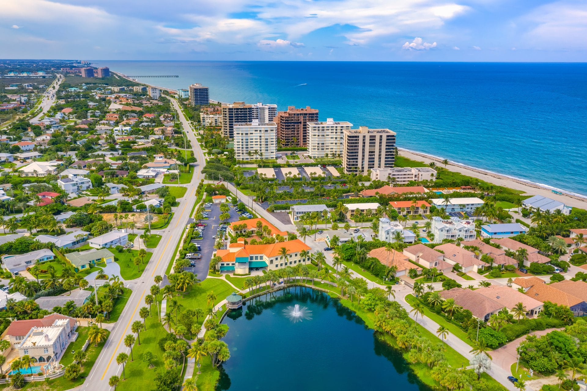 Aerial view of Palm Beach County’s coastline with residential and commercial buildings along the ocean, symbolizing local leadership and community development.