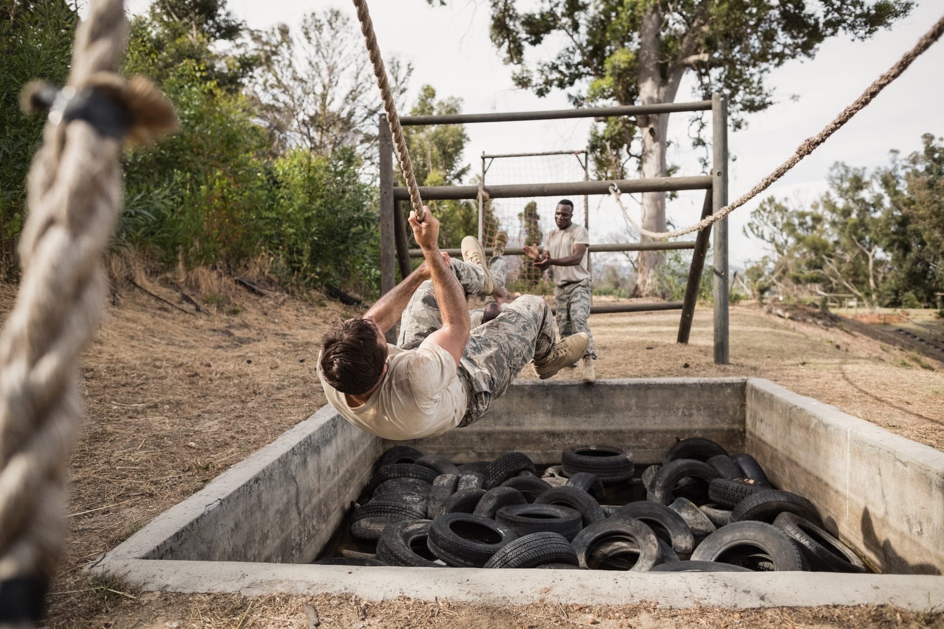 Military service members participating in an outdoor obstacle course, representing veterans and military spouses preparing for new career opportunities.
